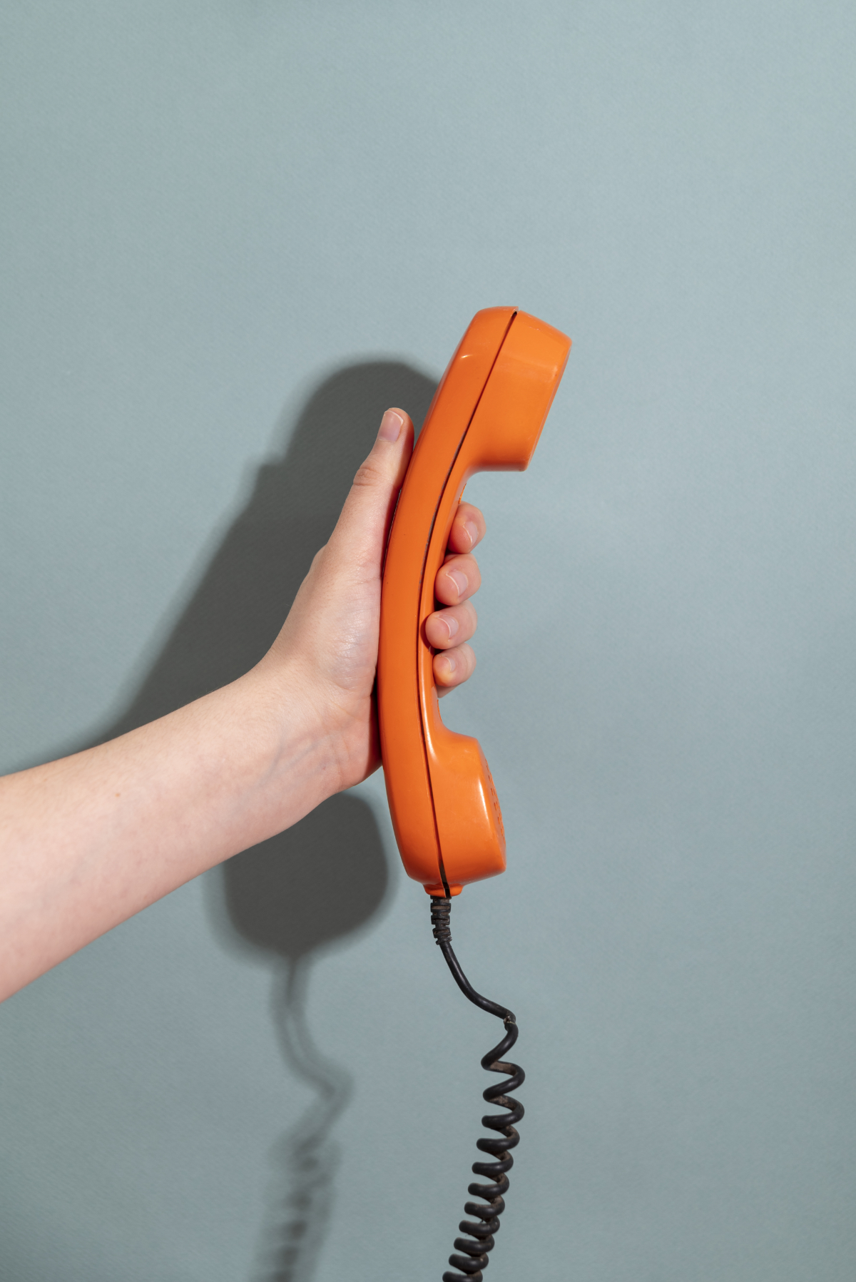 a hand holding a telephone handset